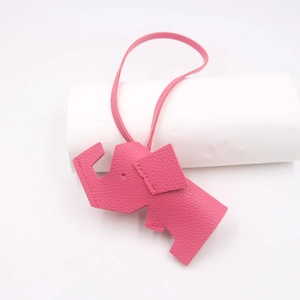 Detailed view of pink elephant bag charm featuring litchi grain PU leather and stitching