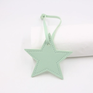 Detail of star-shaped mint green PU leather bag charm with decorative top stitching