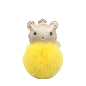 Porte-clés ours à couronne dorée avec pompon jaune vif sur fond blanc pur