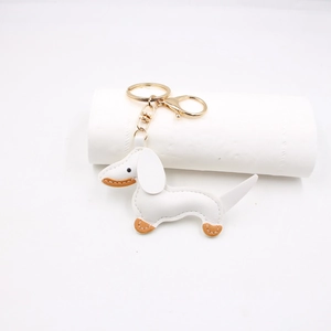 Close-up of white PU leather dachshund keychain with golden lobster clasp and brown stitching