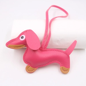 Detail of a pink leather dachshund keychain with fine stitching and a long strap