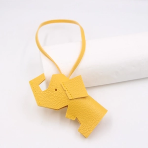 Close-up of yellow elephant leather charm with litchi grain texture and stitching