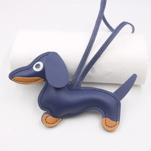 Detailed close-up of dark blue leather dachshund charm with brown accents and litchi texture