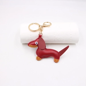 Close-up of wine red leather dachshund keychain with fine stitching and gold clasp
