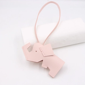 Detailed view of pink elephant bag charm featuring premium lychee grain leather and stitching