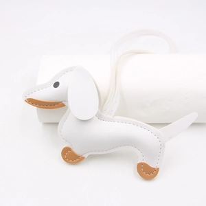Detail of white litchi pattern leather dachshund charm with brown accents and stitching