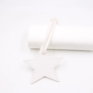 Macro shot of white star-shaped PU leather tag with fine texture and neat stitching