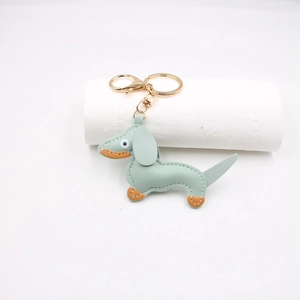 Detail of light green PU leather dachshund keychain with white stitching and gold hardware