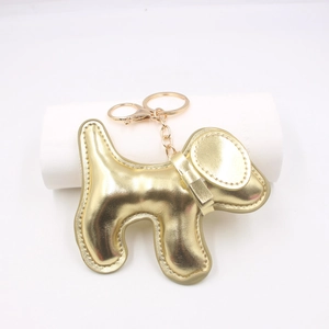 Close-up of golden dog-shaped PU leather keychain with metallic finish and lobster clasp