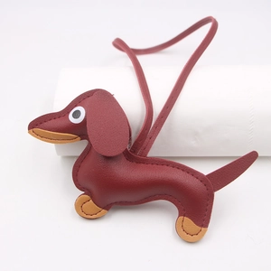 Burgundy and tan leather dachshund dog charm keychain with long tether hanging over white