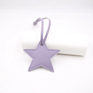 Detail of lavender star PU leather charm with fine white stitching and matching strap