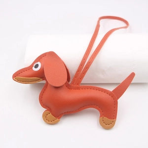 Close-up of leather dachshund bag charm with fine stitching on white cylinder