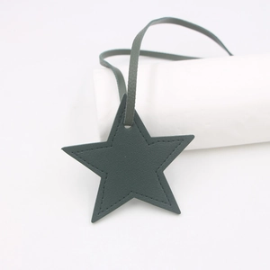 Detail of dark grey star-shaped PU leather bag charm with exquisite stitching and strap