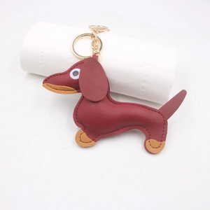 Detailed close-up of handmade leather dachshund keychain with gold metal hardware and stitching