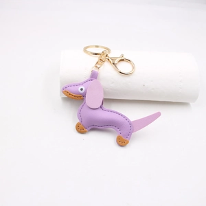Detailed macro view of purple leather dachshund keychain with golden lobster clasp