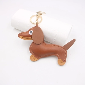 Detail of brown leather dachshund keychain featuring beige stitching and gold hardware