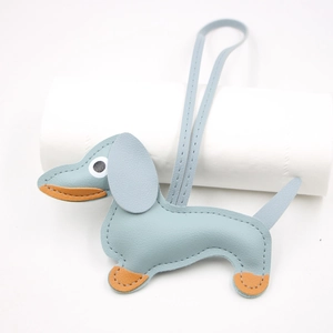 Detail of light blue leather dachshund keychain with orange stitching and long lanyard
