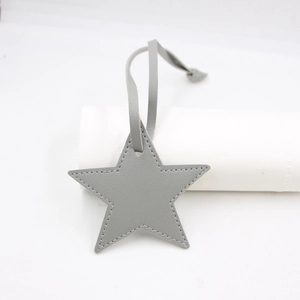 Detailed view of gray PU leather star-shaped bag charm with fine stitching and strap