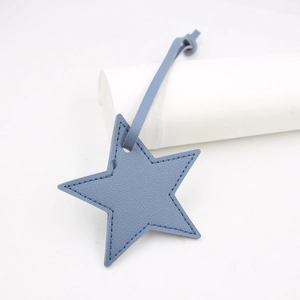 Detail of blue star-shaped PU leather bag charm with high-quality litchi texture and stitching