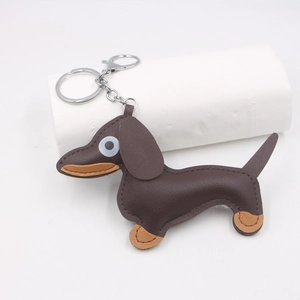 Brown leather dachshund dog charm with metal key ring and spring clip on white background