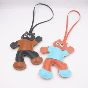 Detail view of handmade cat leather charms with fine stitching and slim leather straps