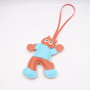 Detail of a cartoon cat leather bag charm featuring orange and blue contrast stitching