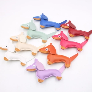 Detailed overhead view of eight colorful leather dachshund charms with contrast stitching