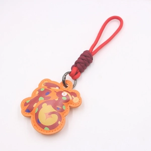 Dettaglio portachiavi anno del serpente in pelle arancione con corda intrecciata rossa