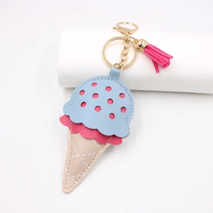 Detail of leather ice cream keychain with pink tassel and gold metal hook accessory