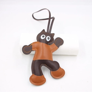 Cartoon cat leather bag charm with brown stitching and matching lanyard on white background