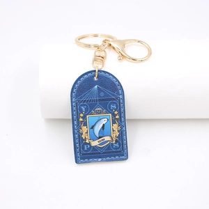 Blue PU leather keychain with gold dolphin print and metal lobster clasp on white background