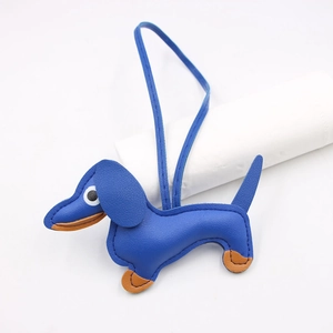 Detailed view of blue leather dachshund charm with fine stitching and brown contrast