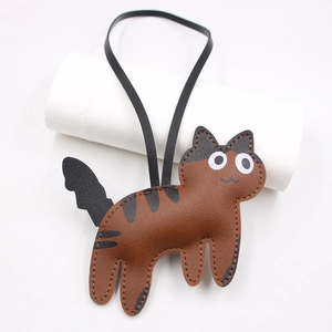 Detailed view of the brown and black faux leather cat charm with litchi texture