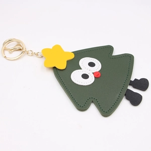 Close-up of a dark green leather Christmas tree bag charm with a gold lobster clasp