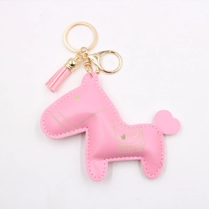 Dettaglio del portachiavi a cavallo in pelle PU rosa con stampe dorate e nappe