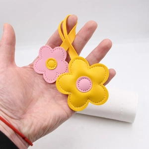 Detail of pink and yellow leather flower bag charms with fine contrast stitching