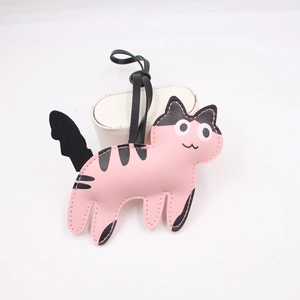 Close-up of pink and black leather cat charm with detailed stitching and black lanyard