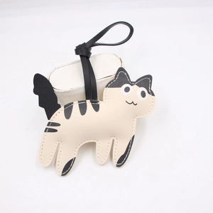 Close-up of cute cow-pattern cat leather charm with white stitching and black lanyard