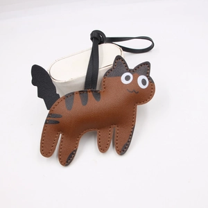 Macro shot of cute brown tabby cat leather bag charm with white headphone case accessory