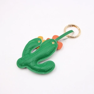 Detail of green leather cactus charm with orange flower accents and gold spring ring