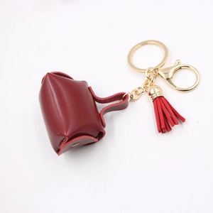 Dettaglio del mini portamonete in pelle rossa con portachiavi dorato e nappa decorativa