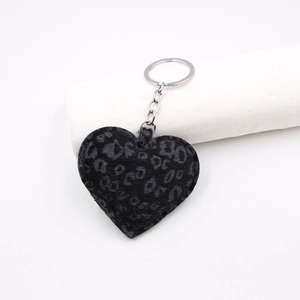 Close-up of leopard print heart keychain featuring grey plush texture and silver metal ring