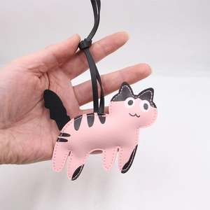 Detail showing the pink faux leather cat charm with black spots and fine edge stitching