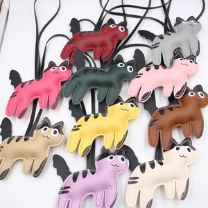 Flat lay of colorful cat-shaped leather bag charms in nine different vibrant PU colors