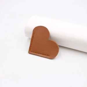 Handmade brown leather heart-shaped bookmark with lychee texture and fine stitching
