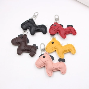 Detailed view of leather horse keychains with handmade stitching and silver metal hooks