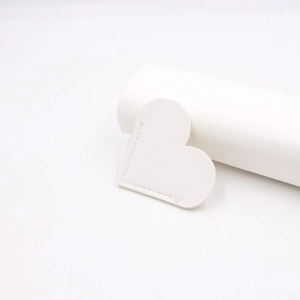 Close-up of white heart leather bookmark with detailed machine stitching textures