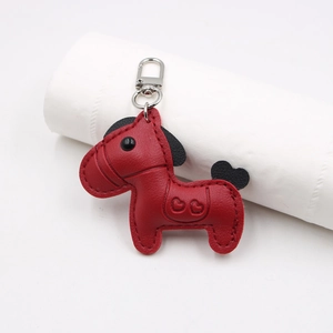 Close-up of red leather horse keychain with heart embossing and silver metal clasp