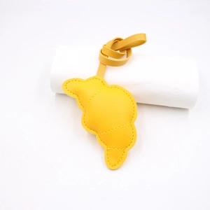 Dettaglio ciondolo borsa a croissant giallo con cuciture a mano e cinturino