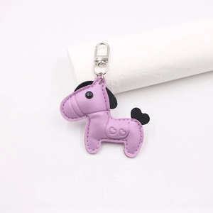 Detailed view of a purple leather horse keychain with silver metal hook and heart embossing